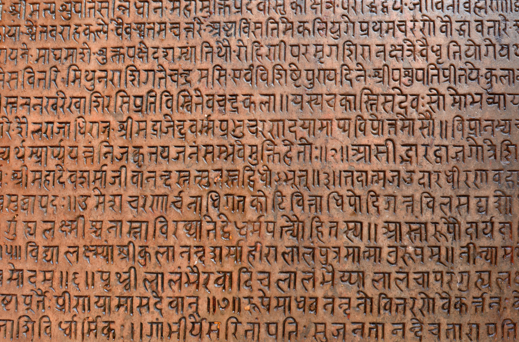 Background with ancient sanskrit text etched into a stone tablet