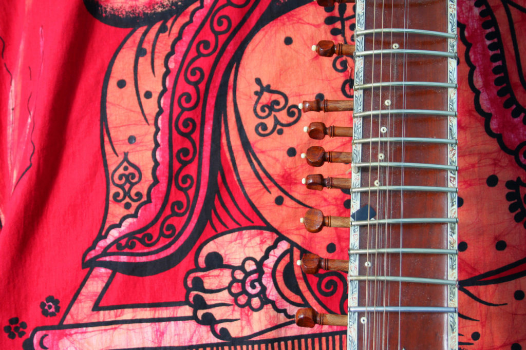 old sitar on red background - ancient indian instrument