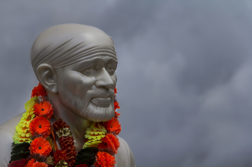 Sai Baba face in a grey sky background